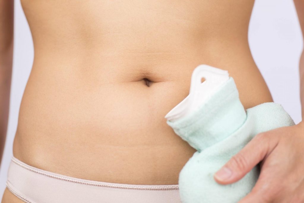 Gadis dengan pad pemanasan di bahagian bawah abdomen, cystitis